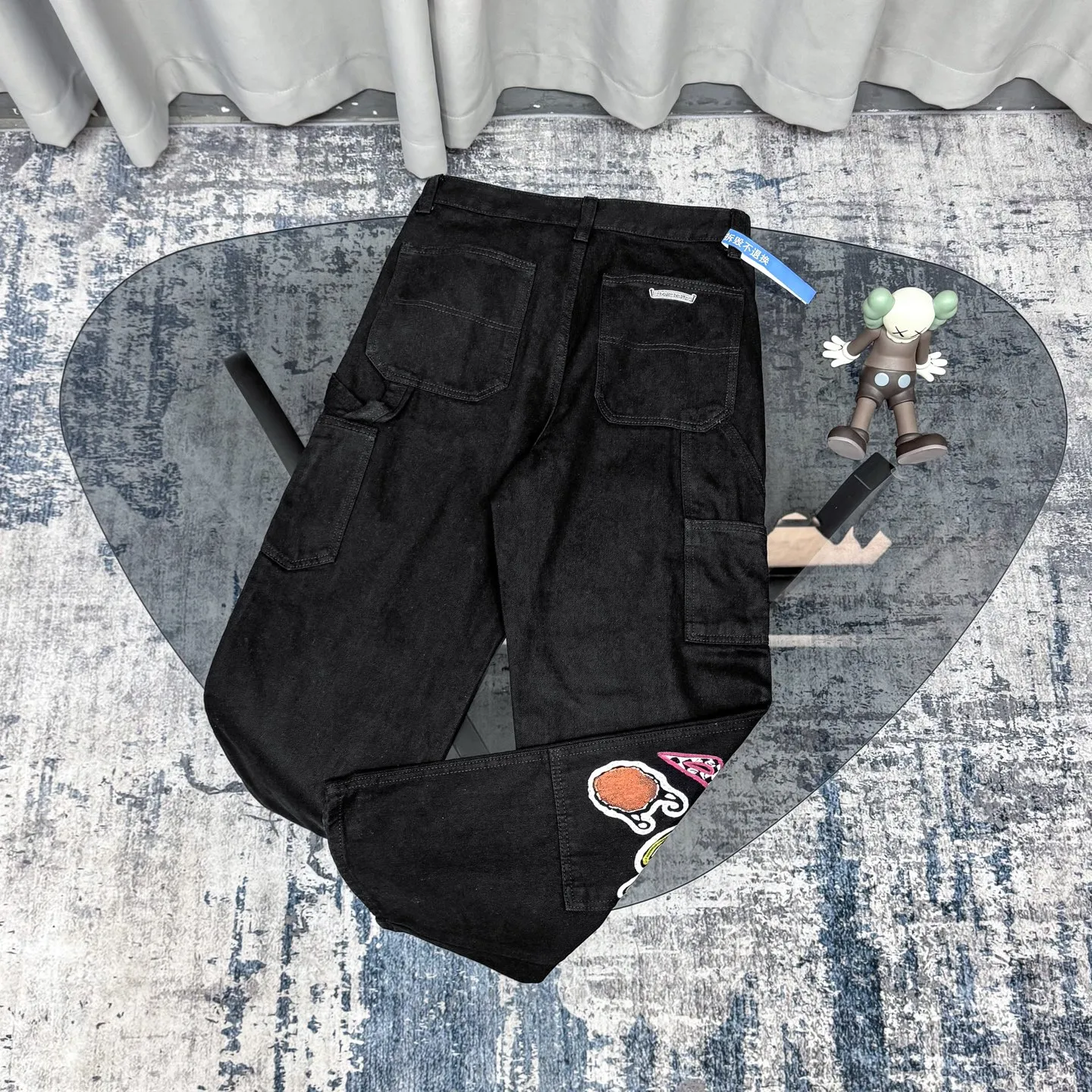 P260 Chrome Hearts Chrome Hearts black multi-element graffiti overalls Chrome Hearts clothing creative director Mattyboy Mattyboy, whose real name is Matt DiGiacomo, is a graffiti artist with a non-school background. He started to serve as the creative director of the Chrome Hearts clothing series in 2018. Since then, Chrome Hearts, which has been injected with young blood, has become popular again. Popular clothing and leather goods, especially the vintage trousers modified product line, must be pre-ordered in stores around the world. Especially patterns like Checker Ball, Checker Eyes and Smiling Lips. The fictional record company logo "SexRecords" often appears in his works, forming his unique style. "I hate humanity, but I love art. Before the end of my life, I just want to do my best to create." ----Matty Boy Mattyboy and vrigil Abloh are also very close. They are both ICONs who bring street culture into luxury accessories. Via.MattyBoy90 (IG) Size: 28/30/32/34/36 Waist: 69/74/79/84/89 Knee circumference: 50/51.5/53/54.5/56 Pants length: 102/104/106/108/110